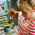 Little girl painting a horseshoe