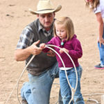 Little girl learning how to cowboy rope