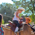 Little girl learning how to ride a horse