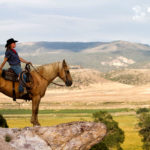 Cowgirl looking over the land on her horse